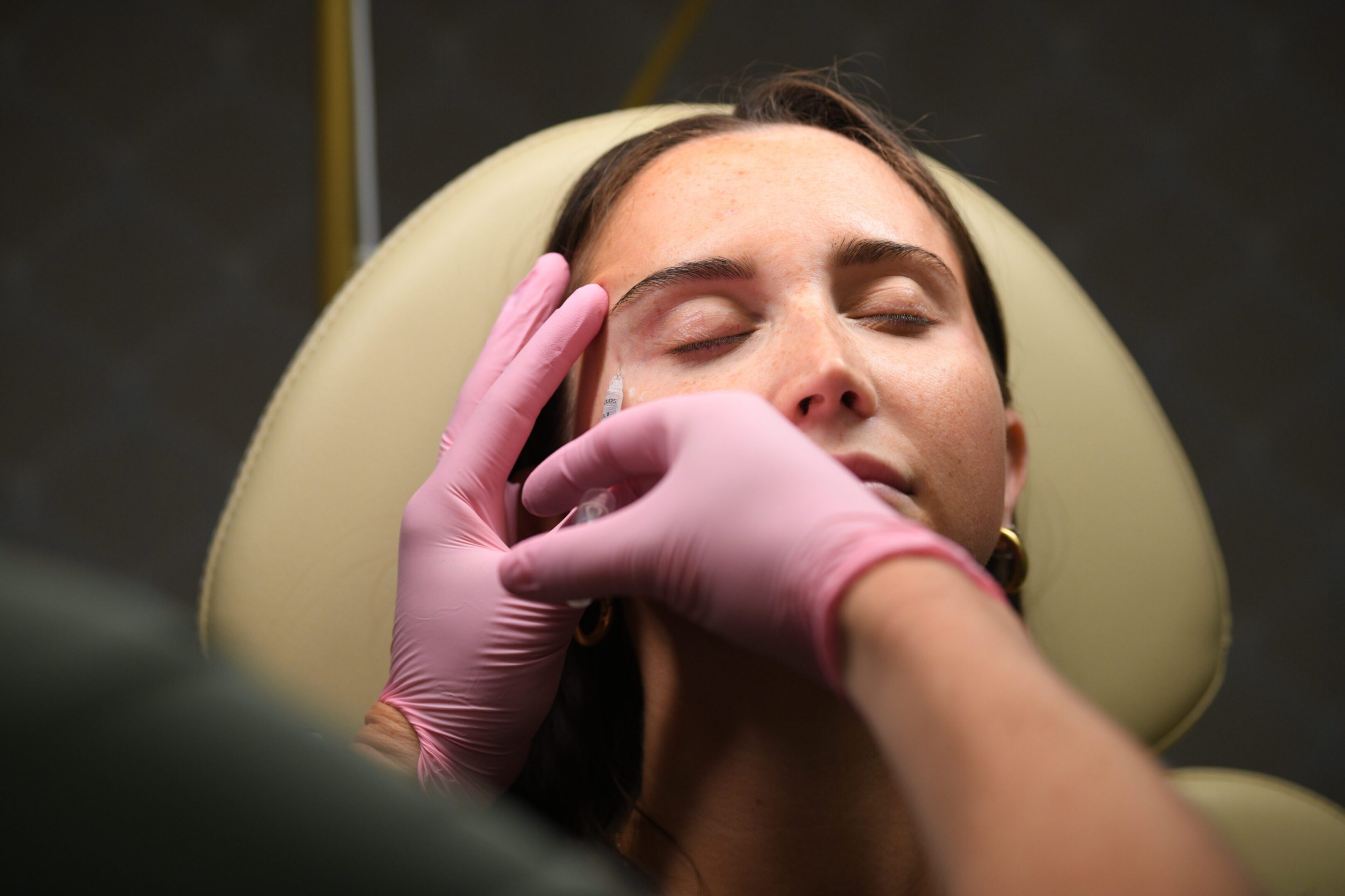 Woman receiving cosmetic facial treatment in clinic